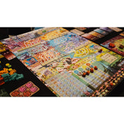 A Buru társasjáték színes, részletgazdag játéktáblája játék közben, különböző régiókkal, jelölőkkel, lapkákkal és fa komponensekkel elrendezve az asztalon.