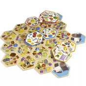 Dobble Catan játékkártyák elrendezve a játéktérre, színes ikonokkal és tárgyakkal.