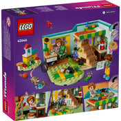 A LEGO Friends Autumn szobája 42646 szett hátoldala, amely bemutatja a szoba és a játszótér részletes belső elemeit, Autumn és Leo figuráival, valamint a borz és madár figurákkal. Láthatóak a színes játékok, lépcső, fényképezőgép, napraforgó, madáreleség, valamint Autumn kedvenc kiegészítői és dekorációi.