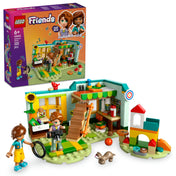 A LEGO Friends Autumn szobája 42646 szett teljes képe, amely bemutatja a részletesen kidolgozott szobabelsőt, Autumn és Leo minifiguráival, a borzfigurával, valamint színes kiegészítőkkel, mint a fényképezőgép, napraforgó, játékok és a játszótér. A doboz képe is látható a háttérben, kiemelve a szett főbb elemeit.