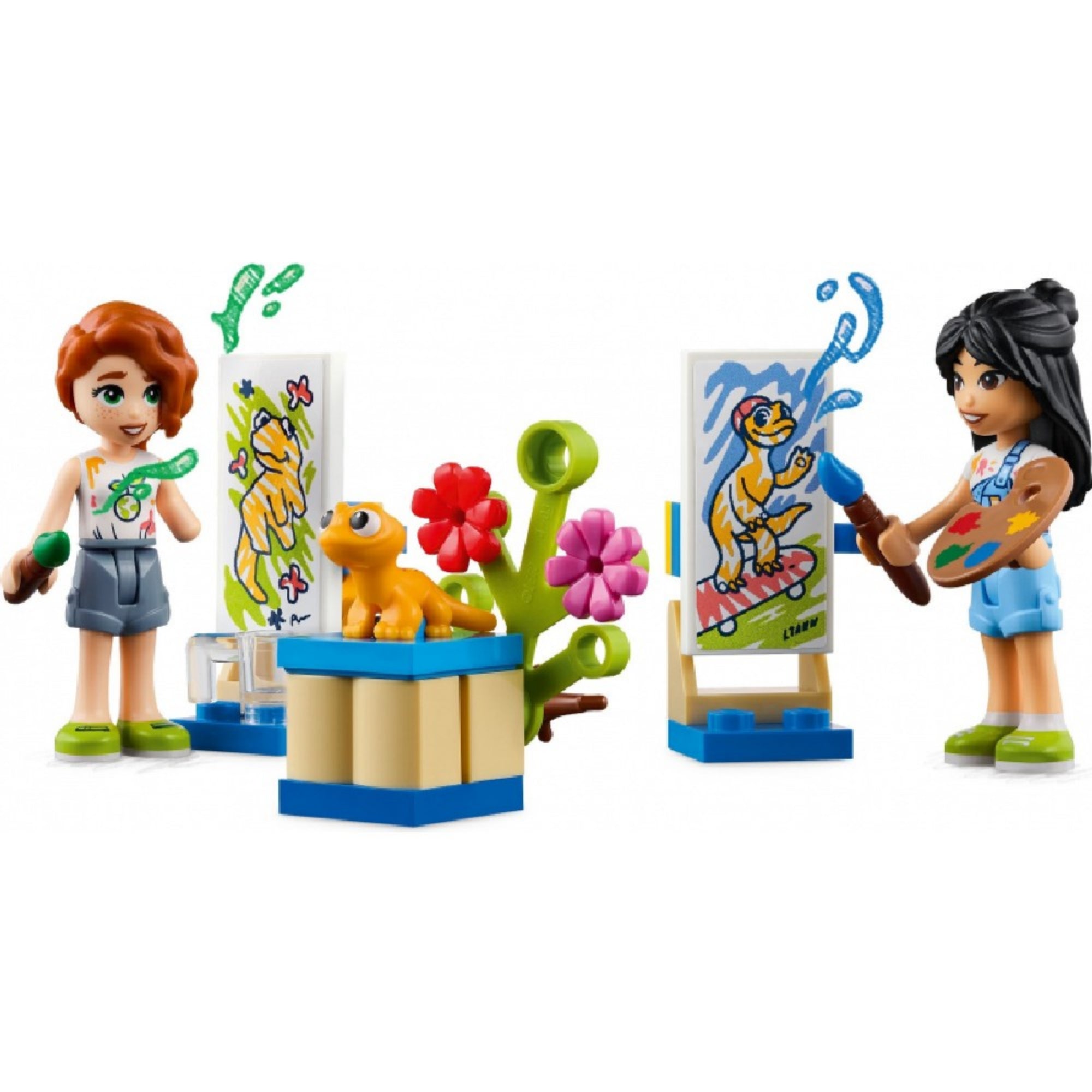 LEGO Friends 41739 Liann szobája – festőművészeti jelenet: Liann és Autumn minifigurák festőállvány előtt dolgoznak. Mindkét karakter élénk színű ruhákban látható, a festmények vidám állatokat ábrázolnak. A középen elhelyezett virágos dísz és sárga gyík teszi még játékosabbá a jelenetet.