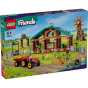 A LEGO Friends Menedékhely háziállatoknak (42617) dobozának előnézeti képe, amely a zöld mezőn álló állatmenhelyet és a hozzá tartozó traktoros játékelemeket mutatja. A bal alsó sarokban Ben, Aliya és Kaya karakterei is szerepelnek. A háttér egy idilli vidéki tájat idéz, ezzel is fokozva a készlet témáját.