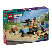 A LEGO Friends Mobil pékség (42606) doboza, amelyen a készlet tematikája látható: egy aranyos mozgó pékség tricikli, két minifigura (Aliya és Jules), egy kutyafigura és egy mókás péksütemény alakú figura séfsapkával. A háttérben egy városi park látható, a LEGO Friends logó és az életkorra vonatkozó ajánlás (6+) is szerepel a dobozon.