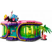 LEGO Friends 41708 Roller Disco Arcade – az épület külső nézete, színes, ívelt, áttetsző falakkal, pálmafával és tűzcsappal a jobb oldalon. A tetőn nagyméretű dísz található: bowlingbábú, videojáték-vezérlők és kiegészítők LEGO elemekből. A modern dizájnú szórakoztató központ kívülről is figyelemfelkeltő.