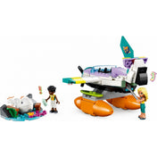 LEGO Friends 41752 Tengeri mentőrepülőgép – a játékjelenetben Zac és Dia minifigurák egy bajba jutott kis fehér bálnát mentenek meg. Az élénk színekben pompázó vízi repülőgép mellett látható a kis tengerparti öböl, ahol az állat pihen, miközben az egyik szereplő itatópalackkal segíti.