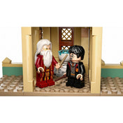 Közeli kép a LEGO Harry Potter készletből, ahol Dumbledore és Harry Potter minifigurái beszélgetnek egy varázspálca és gondolatfűző mellett.