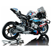 Részletesen kidolgozott, fehér-kék-piros színű LEGO Technic BMW M 1000 RR 42130 motorkerékpár modell oldalnézetből, kiállító állvánnyal.
