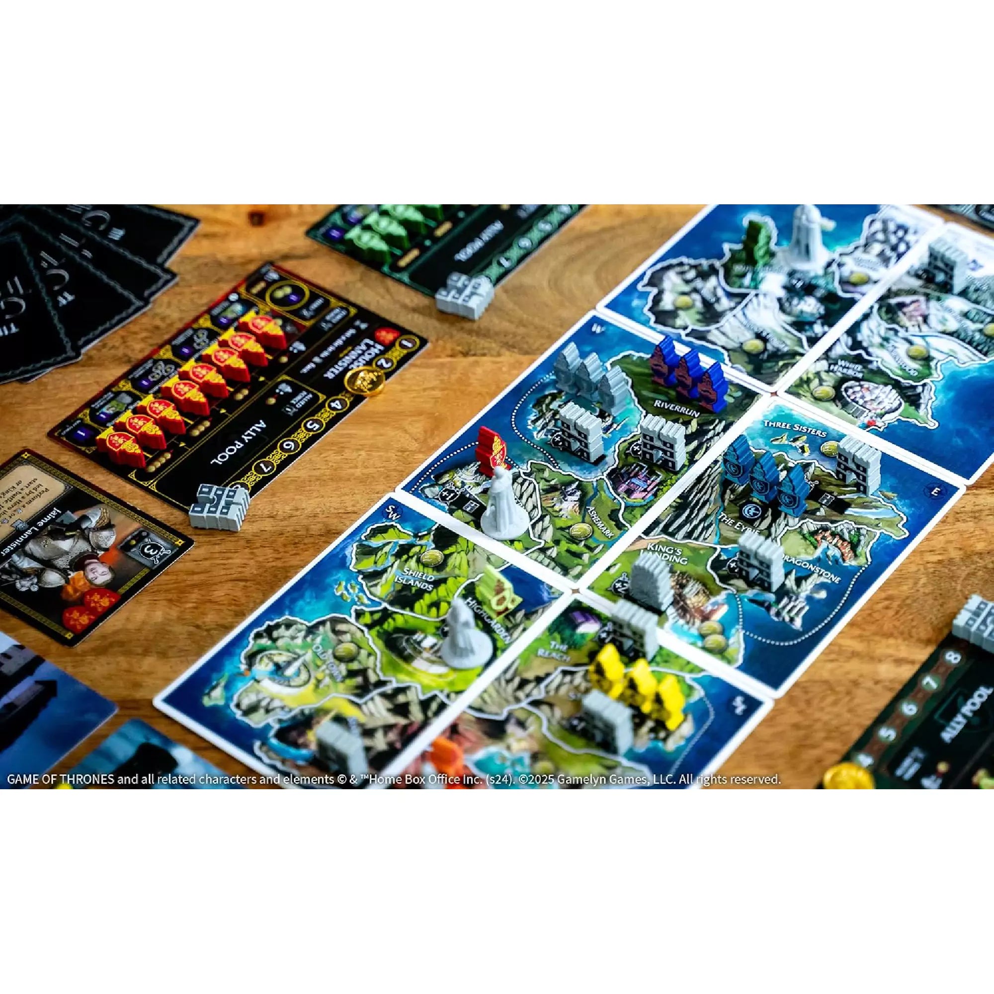 Tiny Epic Game of Thrones játéktér egy másik szögből, színes tornyokkal, karakterfigurákkal és játékostáblákkal a háttérben.