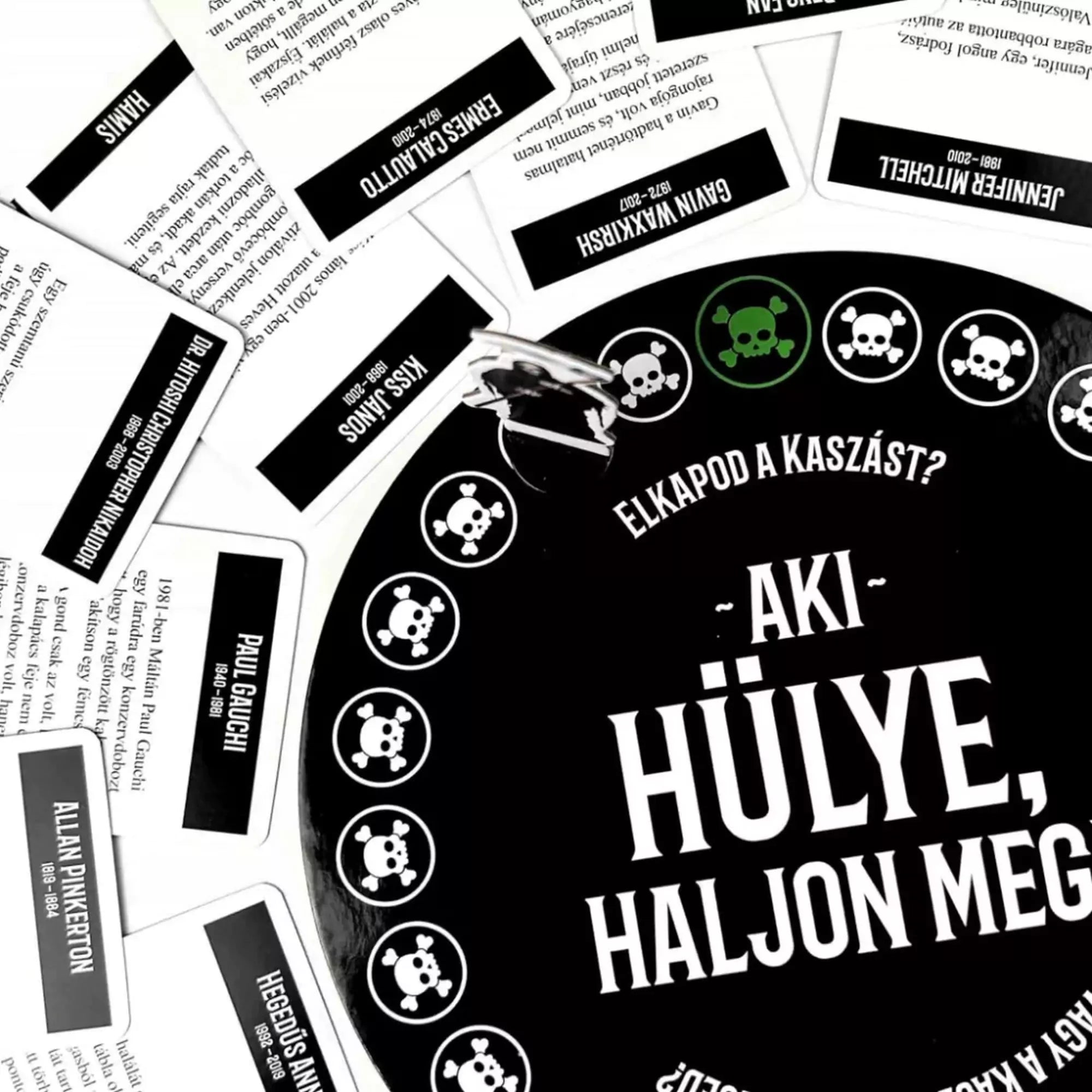 Az Aki hülye, haljon meg! társasjáték kör alakú játéktáblája, körülötte szétszórt kártyákkal