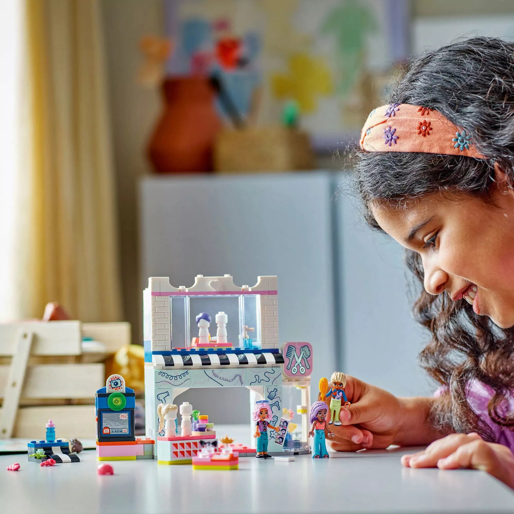 Gyerek a LEGO Friends Fodrászat és fodrászkellékek boltja 42662 játékkal játszik, megalkotva saját kreatív történeteit.