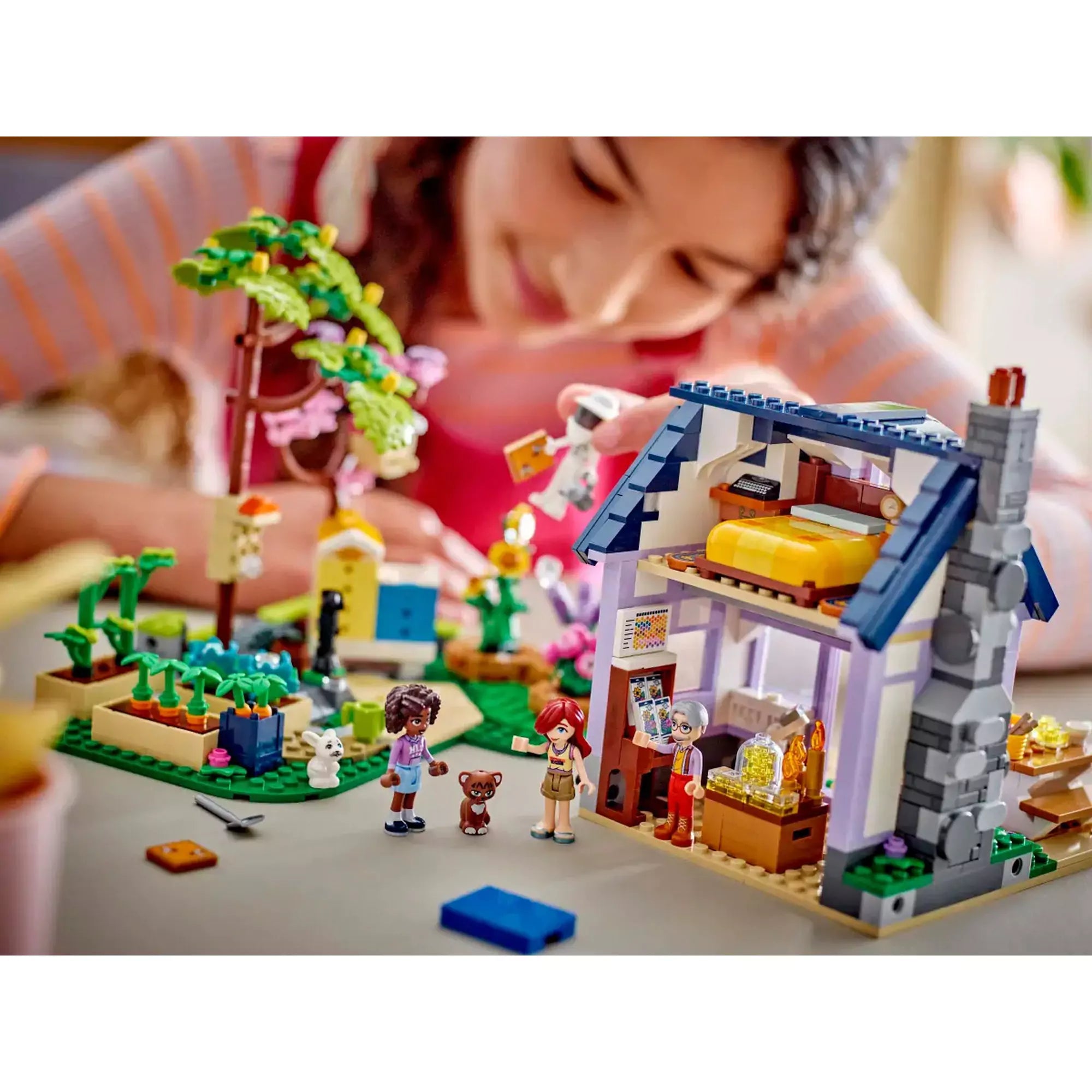 Játék közben LEGO Friends Méhészek háza és virágoskert 42669 modellel, ahol gyerekek építenek és játszanak.