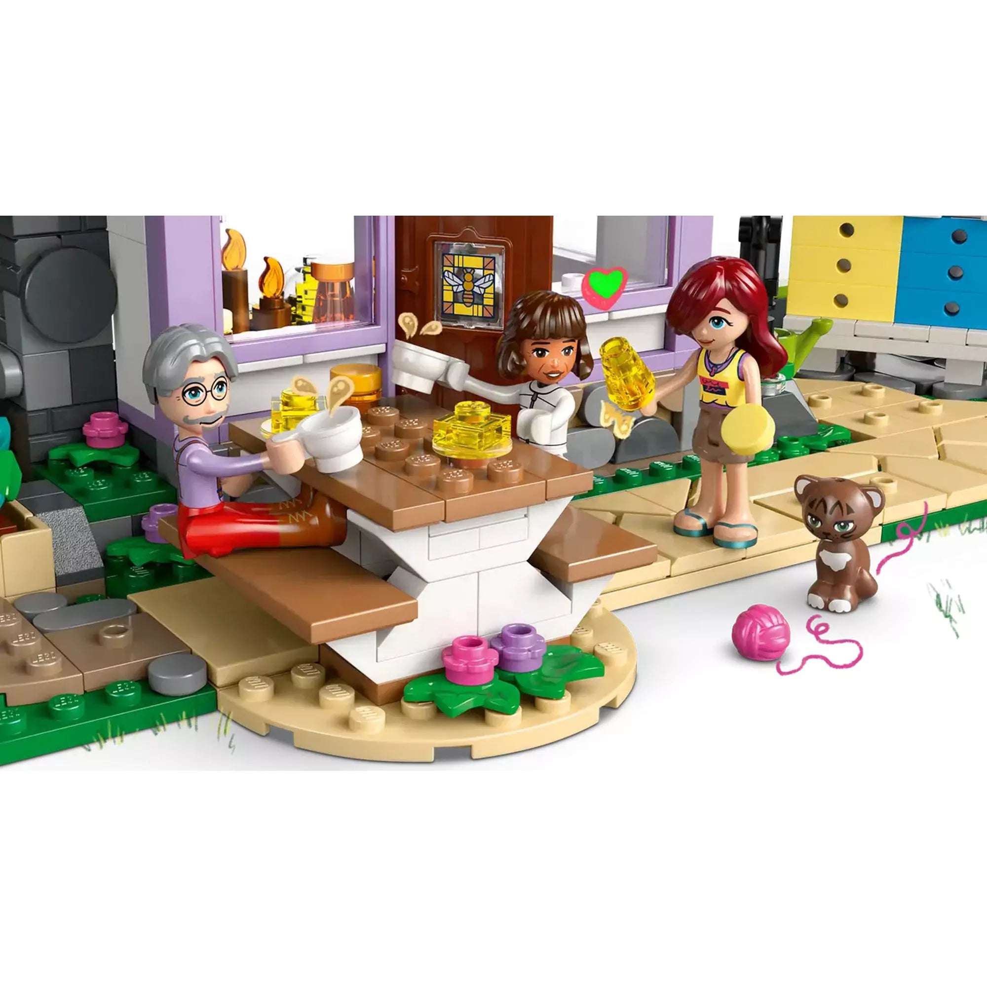 Mézes reggeli jelenet LEGO Friends Méhészek háza és virágoskert 42669 modellben, ahol figurák osztoznak a mézben.
