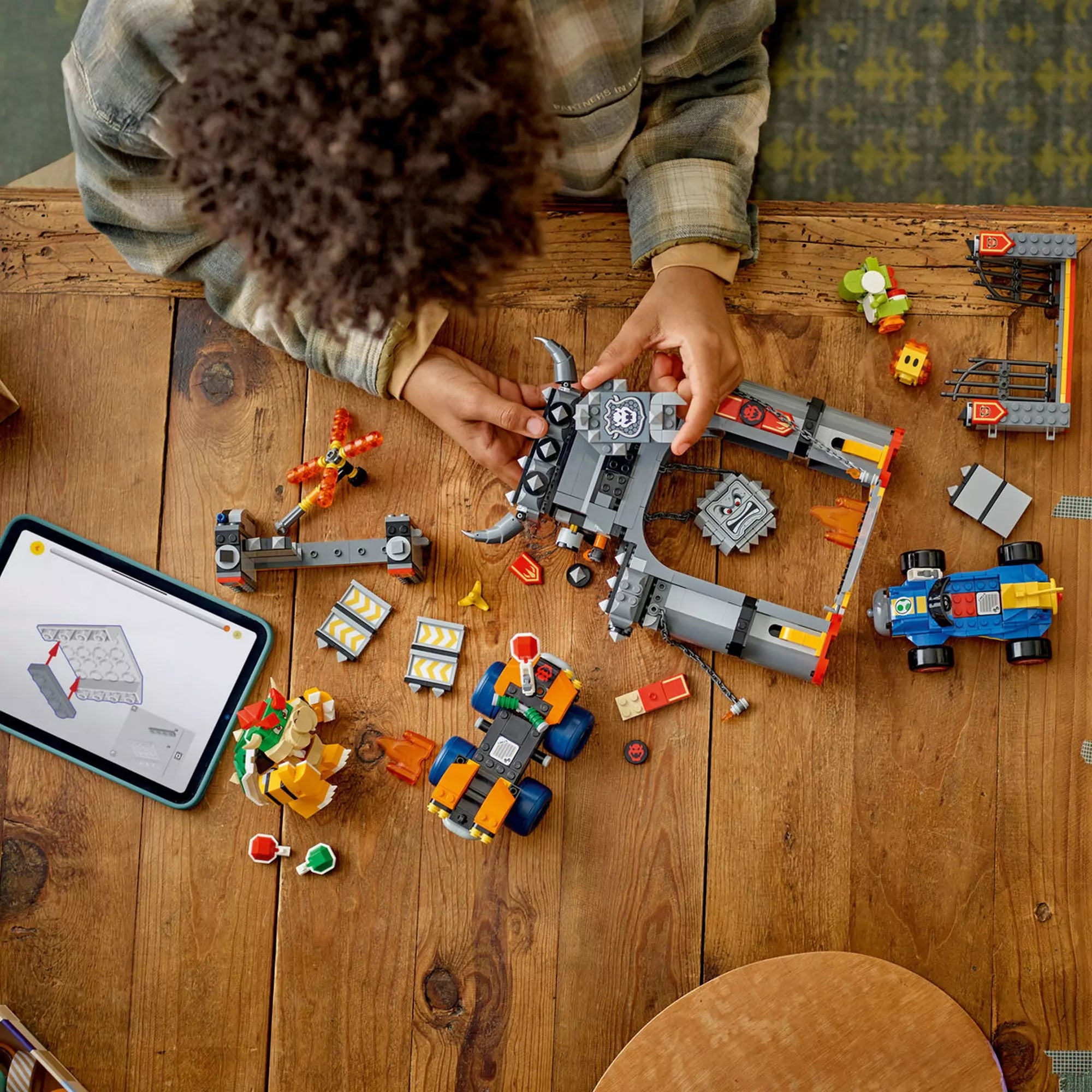 LEGO Super Mario: Mario Kart, Bowser kastélya (72039) építés közben, ahol a gyerek a kastély elemeit szereli össze asztalon.