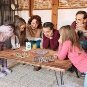 „Család Obiecte Ascunse társasjátékkal játszik egy faasztalon, színes játéktáblák és kártyák társaságában.”