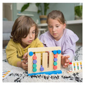 Gyerekek játék közben a Zsiráf Kihívás készségeket fejlesztő játékkal, figyelmesen próbálják kirakni a megfelelő színmintát.
