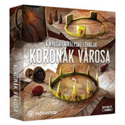 A Nyugati Királyság Lovagjai: Koronák Városa társasjáték doboza, rajta két aranykoronával, pecsétekkel és pergamenekkel egy faasztalon.