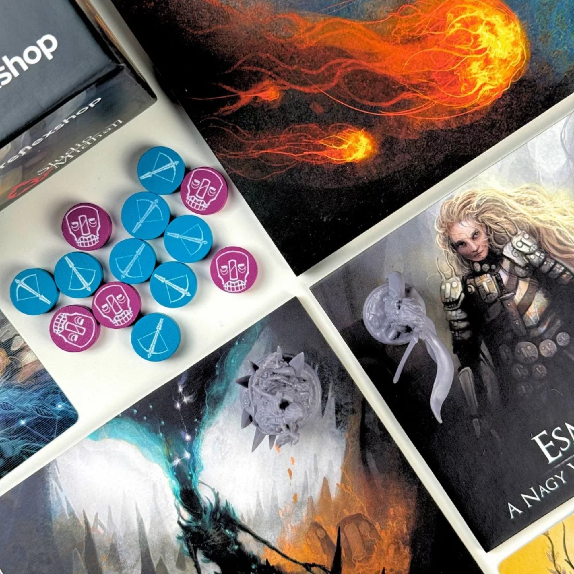 A Fenevad: A Nagy Vadászat társasjáték kiegészítő elemei közelről, színes jelölőkorongokkal, karakterkártyákkal és részletgazdag fantasy illusztrációkkal.