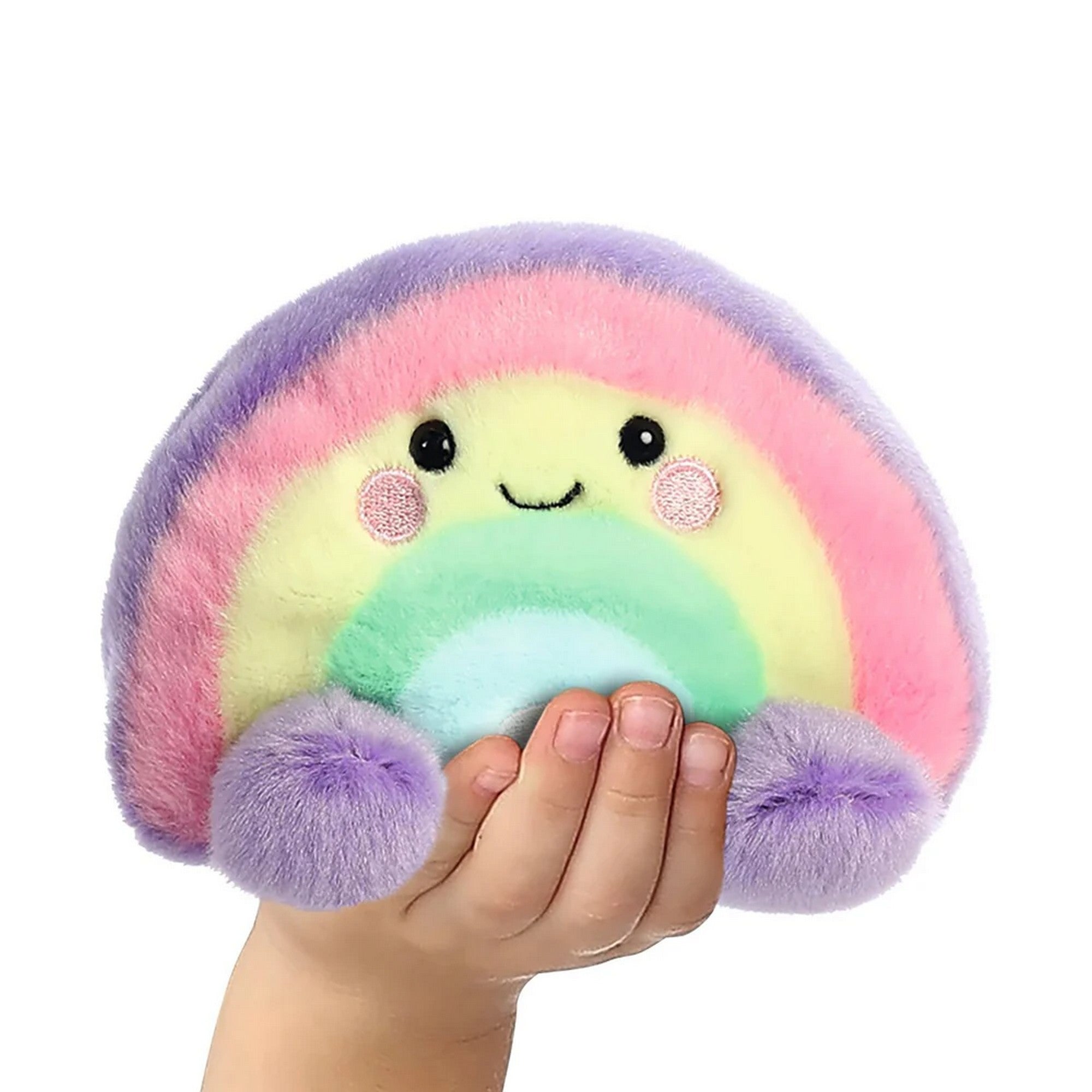 Szivárvány formájú plüss játék kézben tartva, mosolygós arccal, pasztell színekkel és puha, selymes tapintású anyagból készült aranyos kialakítással