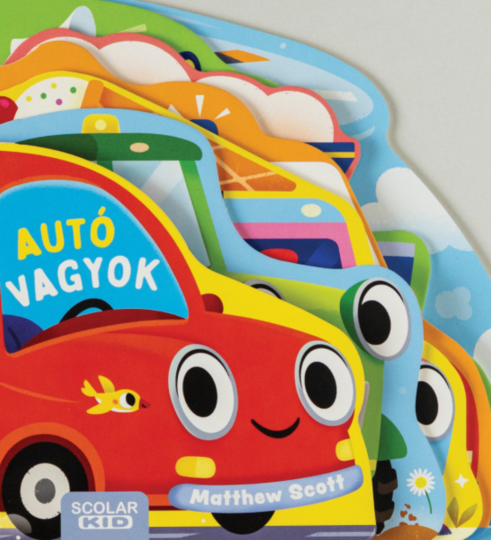 Az Autó vagyok című gyerekkönyv borítója, színes, mosolygós járműveket ábrázoló kivágott formájú lapokkal, a Scolar Kid kiadásában.