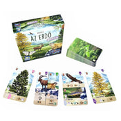 Az „Az erdő: Alpok” társasjáték doboza és kiterített játékkártyái, amelyek alpesi állatokat és növényeket mutatnak, például havasi zergét és fenyőt.