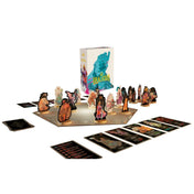 Az Uralkodó társasjáték teljes játékkészlete felállítva, középen a játéktáblával, körülötte álló fa talpas figurákkal és több sorban elrendezett, illusztrált kártyapaklikkal.