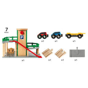 BRIO World Parking Garage tartalma: többszintes parkolóház, piros és kék autó, sárga tréler, síncsatlakozók és kiegészítők.