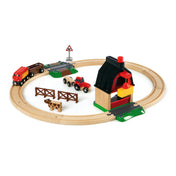 BRIO World Farm Railway Set teljes tartalma: kör alakú fa sínpálya, piros mozdony, traktor, pajta, tehén, kerítés és közlekedési tábla.