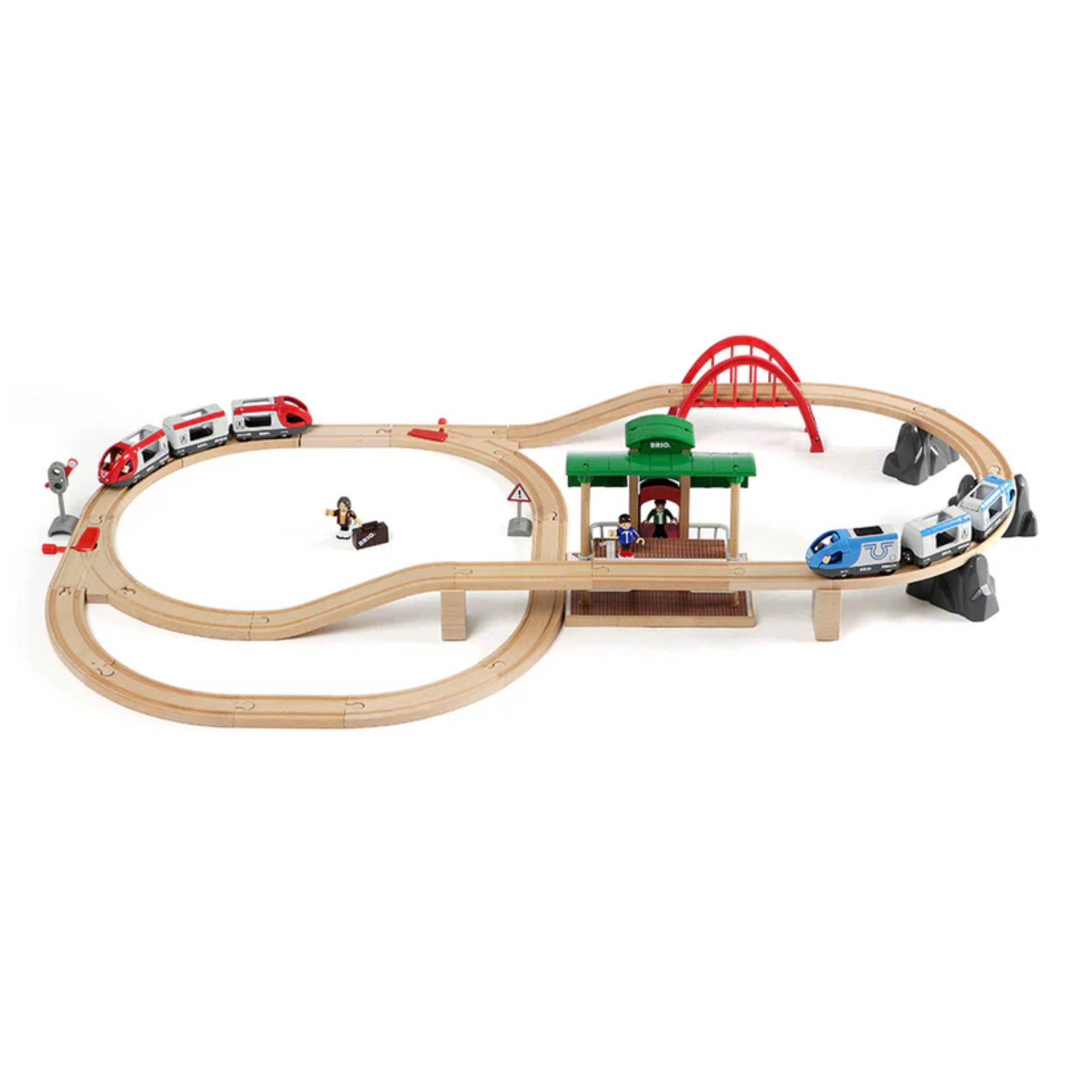 BRIO World Travel Switching Set összeállított vasúti pálya felülnézetből, két vonattal, piros híddal, zöld állomással és játékfigurákkal.