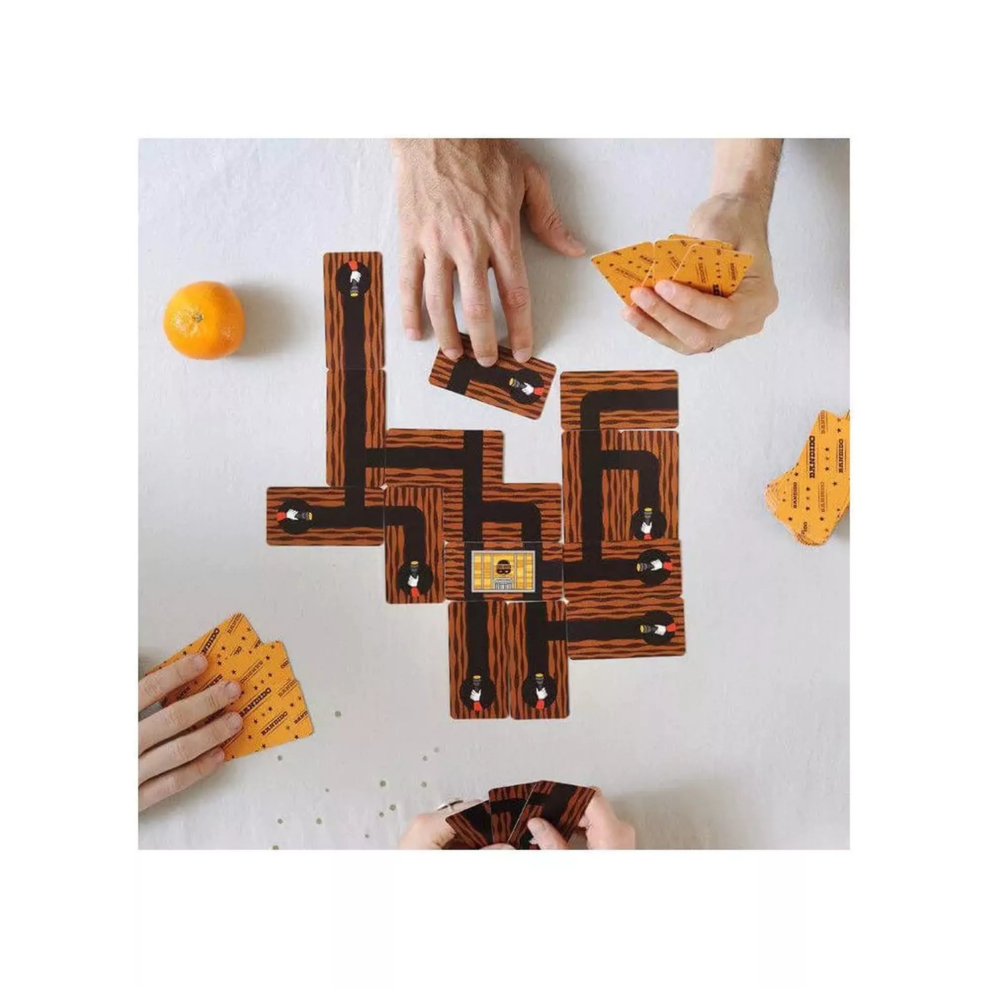 A Bandido társasjáték játékmenet közben: a játékosok kártyákat helyeznek le, hogy elzárják a rab menekülőútjait a táblán.