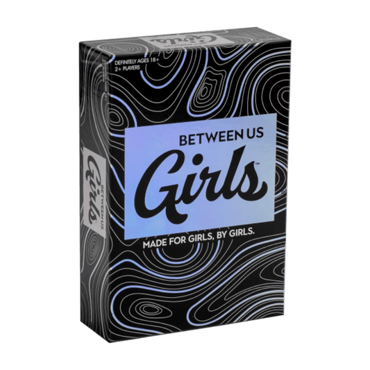 Between Us Girls társasjáték doboza, fekete alapon hologramos hatású felirattal és domborzati mintával, alul a szöveg: Made for girls, by girls.”
