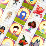 Boo Buli kártyák közelről – jelmezes gyerekek és színes szörnyek illusztrációi teliholdas háttérrel.