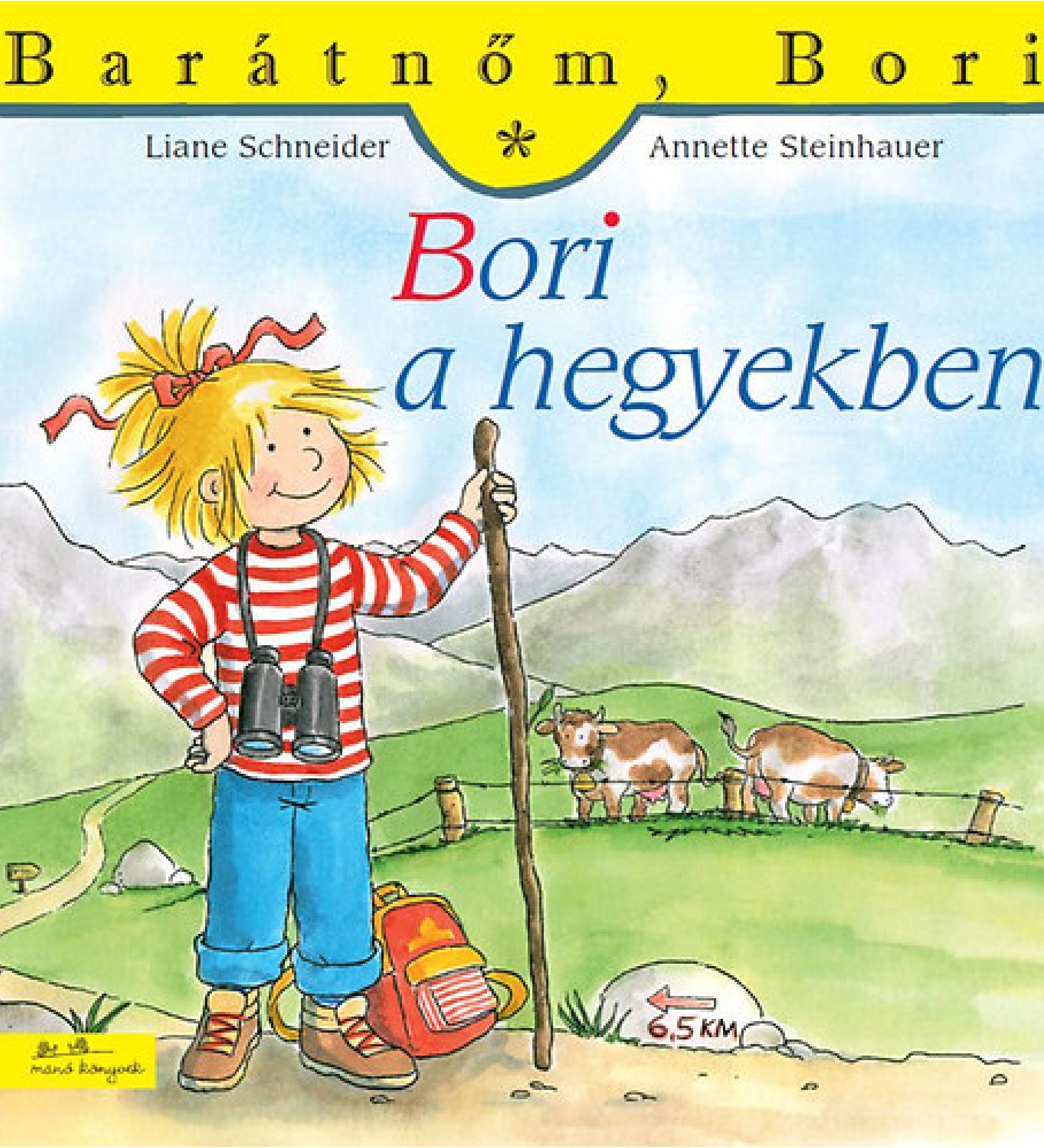 „Bori a hegyekben” borító – Bori túrázó ruhában, hátizsákkal és távcsővel egy hegyi ösvényen áll, háttérben tehenek, hegycsúcsok és egy 6,5 km-es tábla látható.
