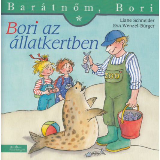 „Bori az állatkertben” borító – Bori és egy barátja izgatottan figyelik, ahogy egy gondozó halat ad egy fókának. A háttérben színes labda és vödör, az előtérben a fóka állva várja a jutalmat.