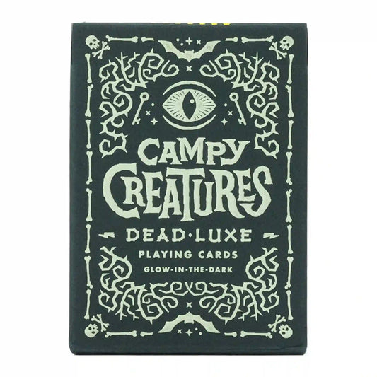 Campy Creatures Dead Luxe playing cards doboz, sötét alapon világító hatású díszítéssel, koponya- és szemmotívumokkal.