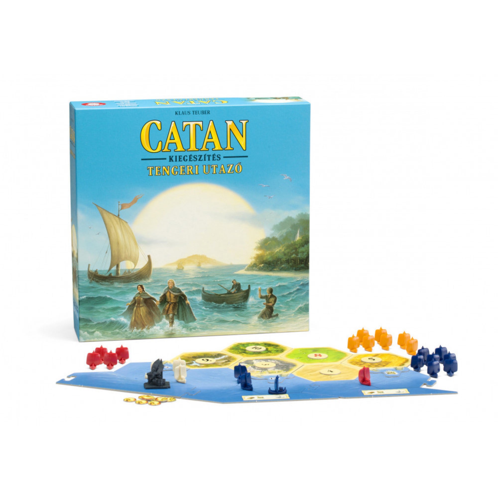 A Catan – Tengeri utazó kiegészítő társasjáték világoskék doboza a tengerparton kikötő hajóval és utazókkal, előtte játéktábla hatszögű mezőkkel, színes bábukkal és arany érmékkel.