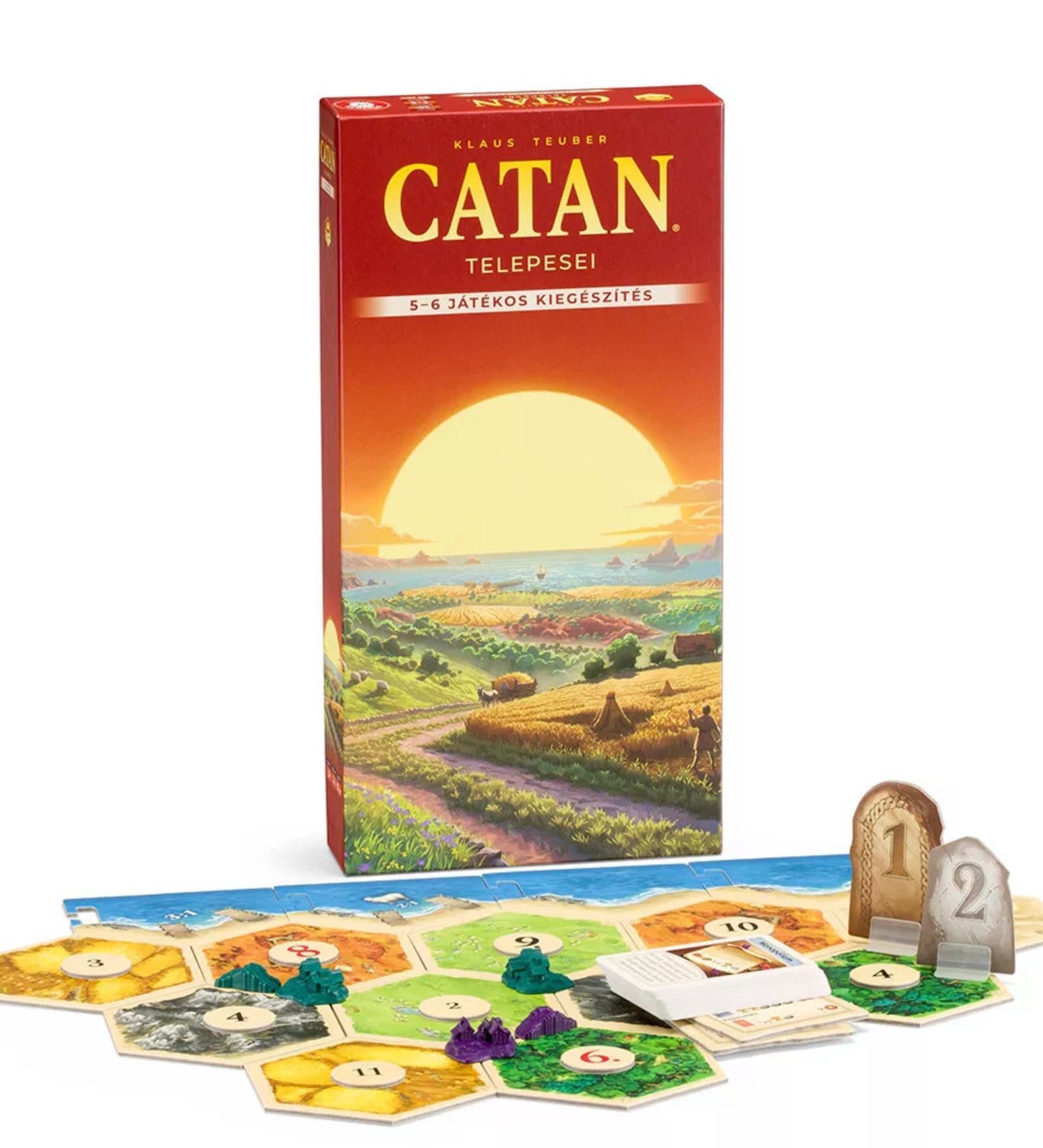 A Catan telepesei – 5-6 fős kiegészítő magyar nyelvű kiadásának doboza naplementés tájképpel, előtte hatszögletű mezőkből álló játéktábla, kártyák, fafigurák és győzelmi pontjelzők elrendezve az asztalon.