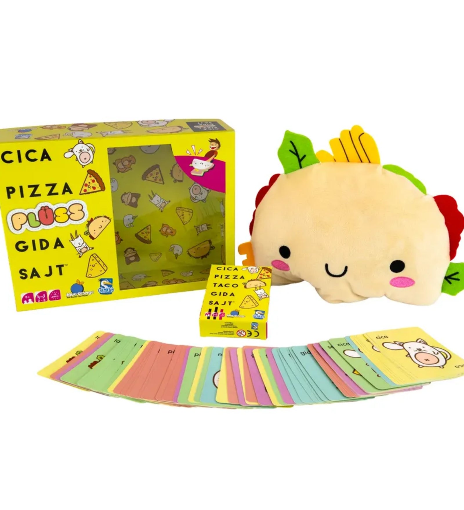A Cica, pizza, plüss, gida, sajt társasjáték teljes készlete: a sárga, vidám grafikákkal díszített doboz, a mosolygó taco plüss, valamint a színkódolt, cuki illusztrációkkal ellátott játékkártyák szétszórva a doboz előtt.