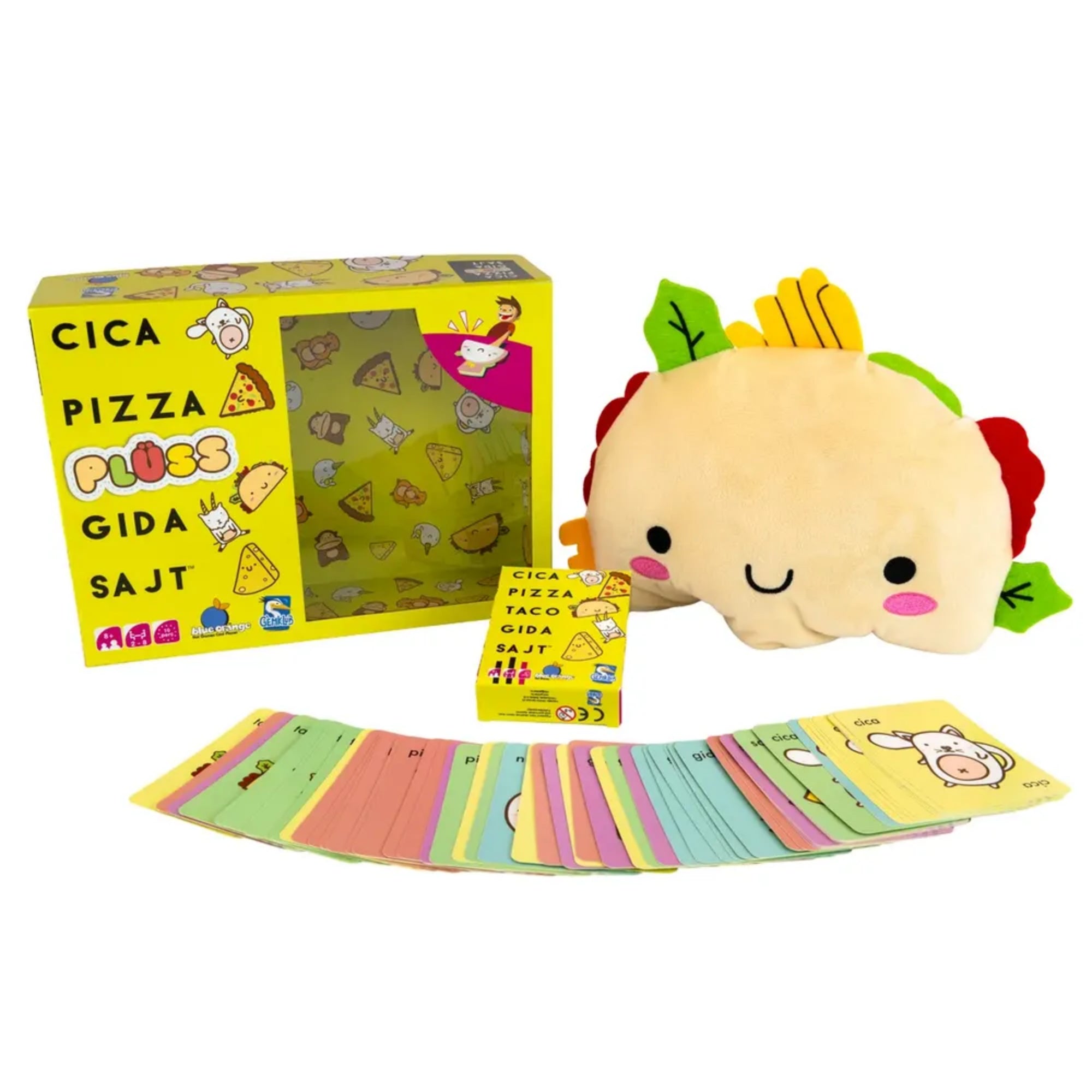 A Cica, pizza, plüss, gida, sajt társasjáték teljes készlete: a sárga, vidám grafikákkal díszített doboz, a mosolygó taco plüss, valamint a színkódolt, cuki illusztrációkkal ellátott játékkártyák szétszórva a doboz előtt.