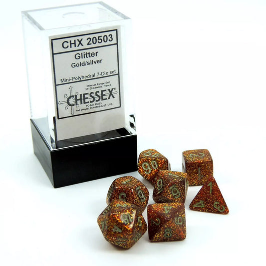 A Chessex Glitter Gold/Silver 7 darabos poliéder kockakészlet, átlátszó dobozban csomagolva, a kockák arany csillámokkal és ezüst számokkal díszítve.