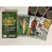 A képen az El Gran Tarot Esoterico kártyacsomag és néhány kártyalapja látható. A bal oldalon a zöld, arany feliratokkal díszített doboz található, amelyen szerepel, hogy a csomag 78 színes tarot kártyát és útmutatót tartalmaz. Mellette három részletesen illusztrált kártyalap: „La Consultante” (a kérdező), „El Carro de Hermes” (Hermész szekere) és „El Ciclo” (A ciklus), amelyek gazdag szimbólumvilággal és élénk színekkel jelenítik meg a tarot ezoterikus jelentéseit. 