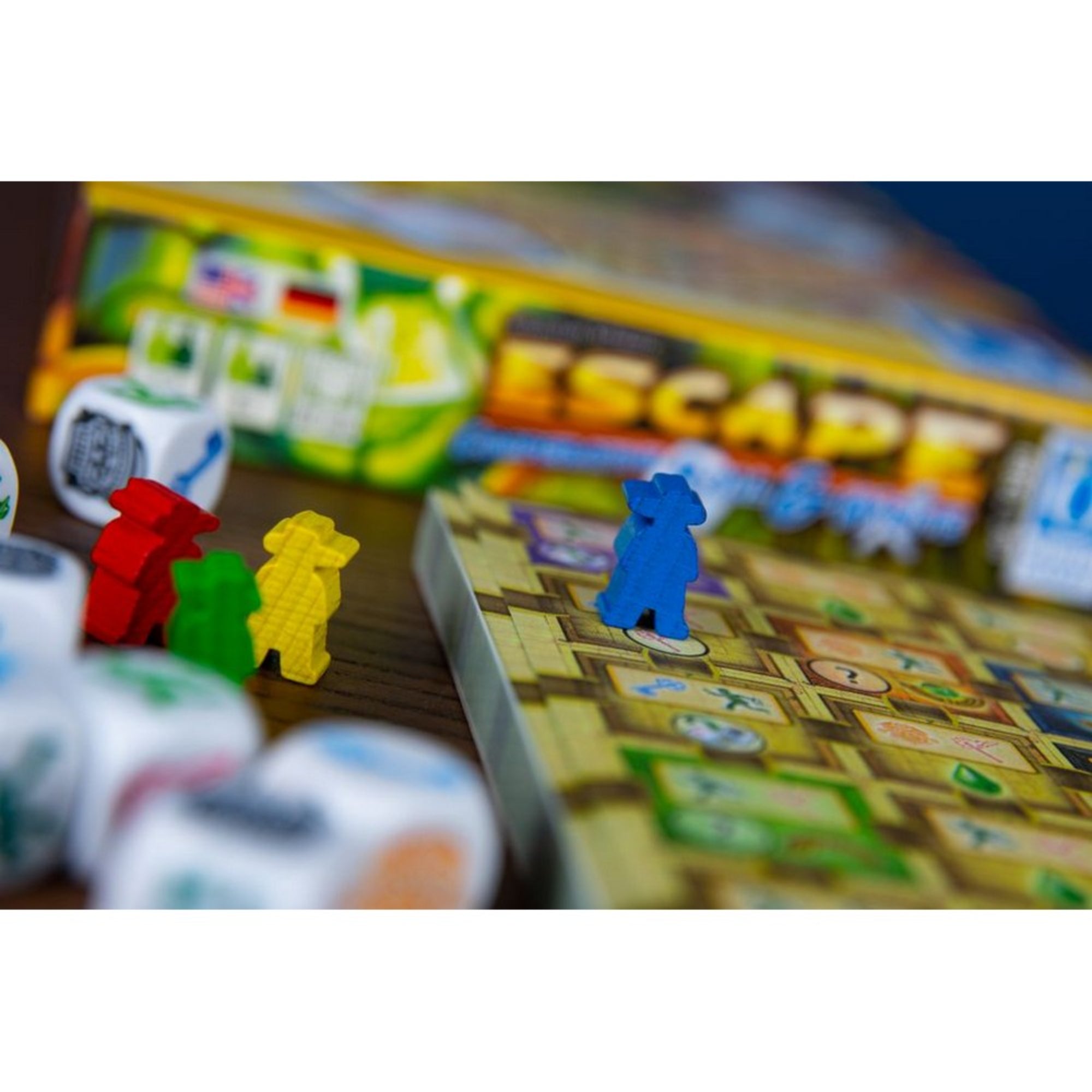 Az Escape: Roll & Write társasjáték színes játékosfigurákkal és dobókockákkal a játéktáblán, háttérben a doboz részlete látható.