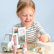 Kislány játszik a Tender Leaf Kitty’s Milkshake Van fa tejbárral, fagylaltokat és italokat szolgál ki a macskafiguráknak.