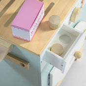 A Tender Leaf fa mosoda részlete, nyitott fiókkal és fa mosószeres dobozokkal, a tetején rózsaszín “Wonder” feliratú kartondoboz látható.