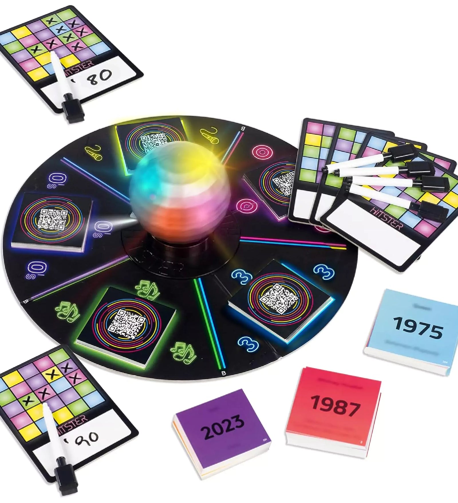 Hitster Music Bingo társasjáték tartalma: színes világító diszkógömb, játékmező, zenekártyák évszámokkal, pontozólapok és filctollak.