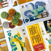 Hội Phố – A hatalom ára társasjáték kártyái és dong érméi közelről, sárkányos és kereskedős illusztrációkkal.