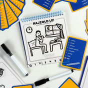 Képzavar társasjáték feladvány rajzfüzetben, egyszerű rajzzal egy esti jelenetről, mellette kártya és filctollak a játékhoz.