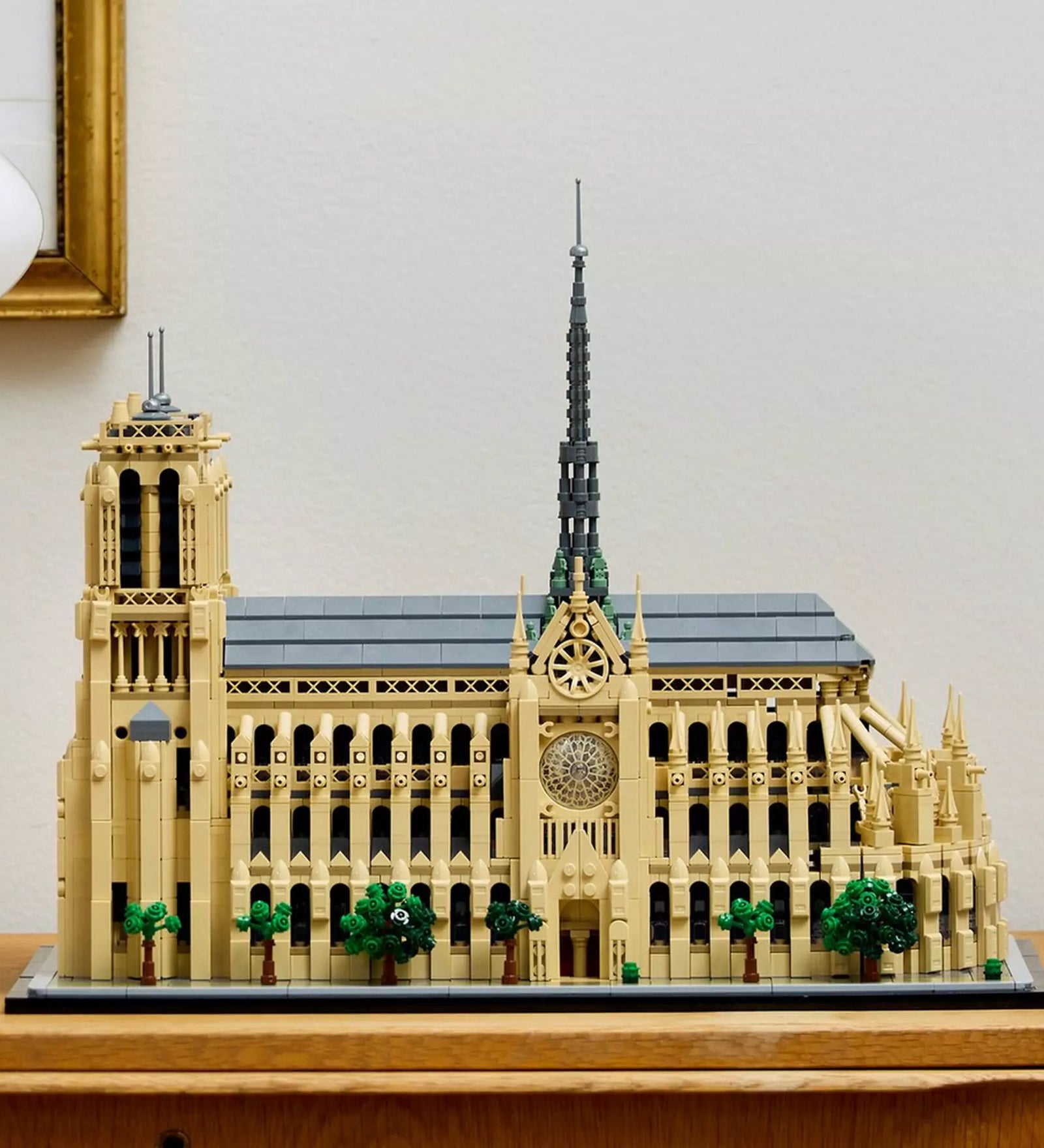 A LEGO Architecture Notre-Dame de Paris (21061) készlet modellje kiállítva egy polcon, oldalnézetből, elegánsan berendezett szobabelsőben.