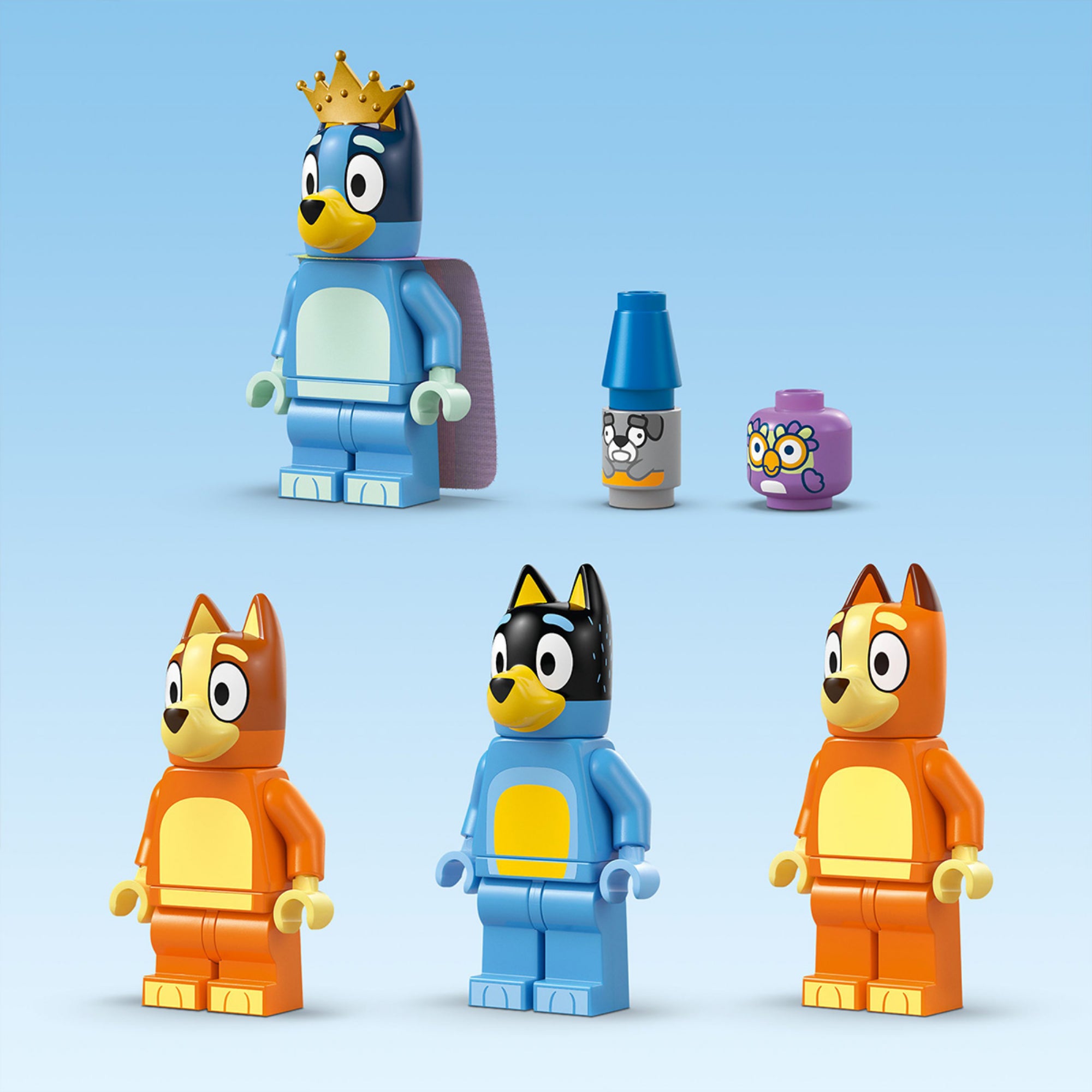 Bluey, Bingo, Bandit és Chilli minifigurák állnak világoskék háttér előtt. Bluey királyi koronát és köpenyt visel. Két kis épített kiegészítő is látható: egy éjjeli lámpa és egy játékfigura. A szereplők élénk színekben, részletes nyomtatással jelennek meg.