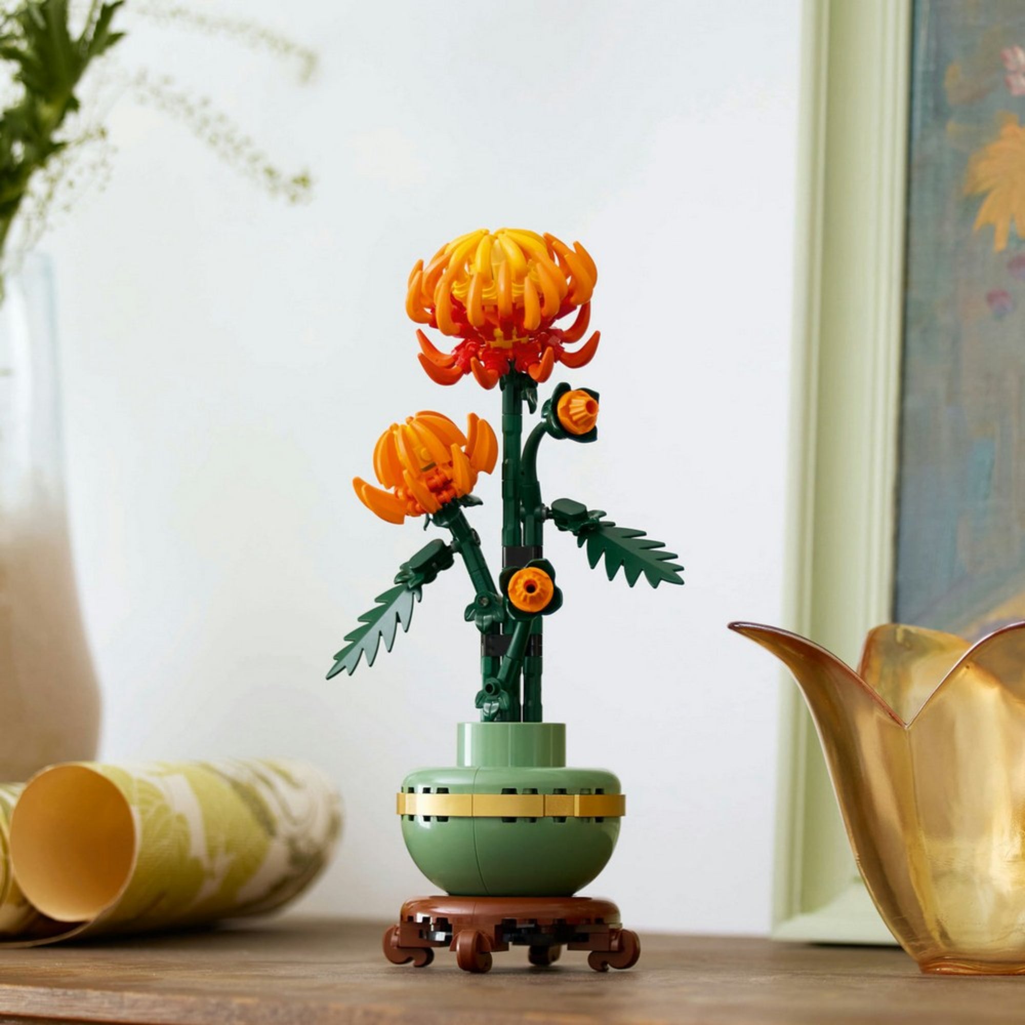A LEGO Botanicals 10368 Chrysanthemum készlet teljes építménye egy fa asztalon elhelyezve, elegáns dekorációs környezetben.