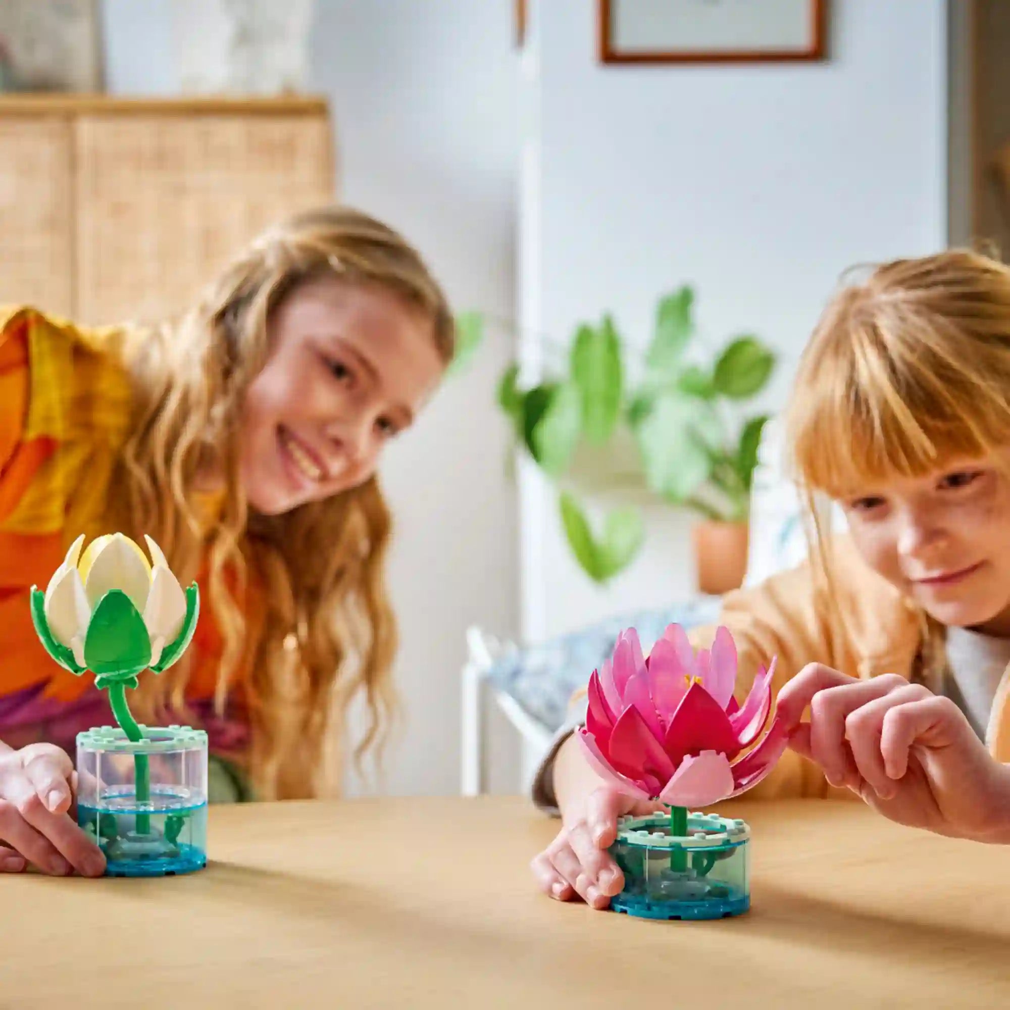 LEGO Botanicals Tavirózsák (11511) építőkészlet használat közben, ahol két gyermek a színes tavirózsa modelleket építi és csodálja egy asztalon.